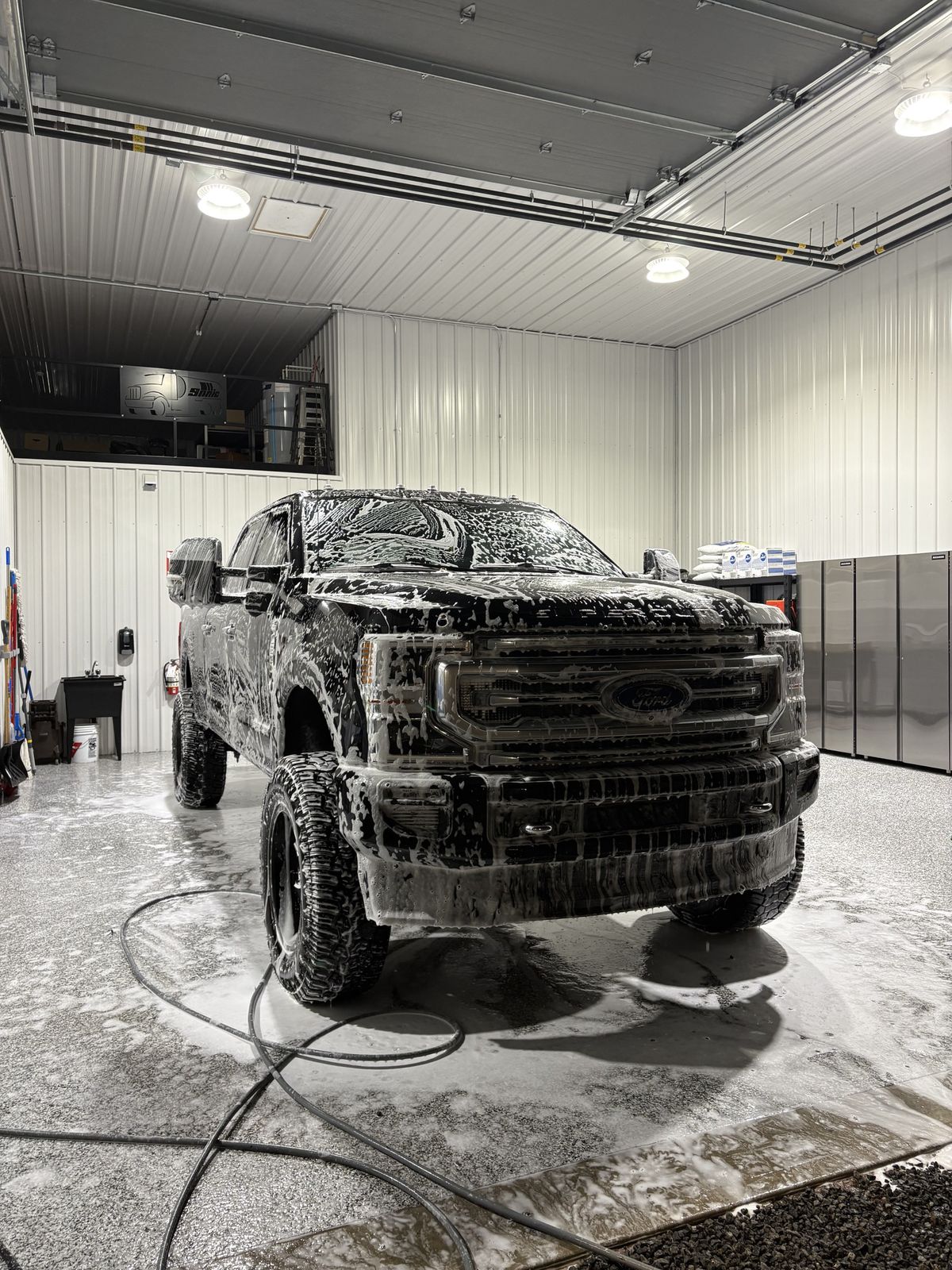 Pickup Ford Super Duty recouvert de mousse active pendant un détaillage à l'atelier